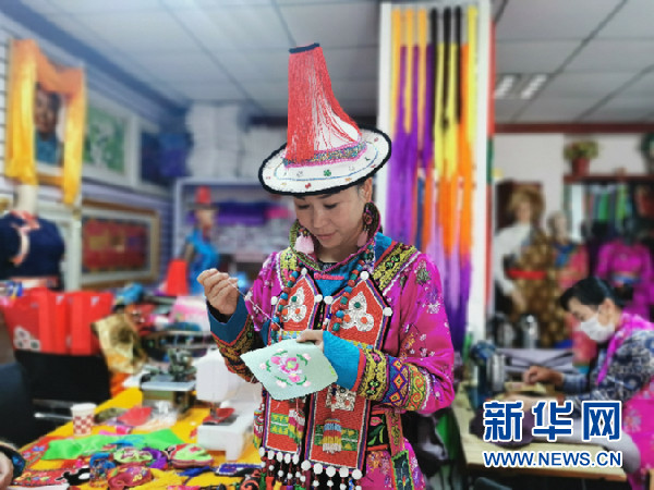 潘小红在绣制裕固族姑娘服装上的胸牌.新华社记者 何问 摄