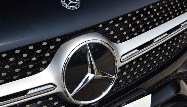 形进气格栅,中间横贯了一条粗壮的镀铬饰条,而且还悬挂了奔驰经典车标