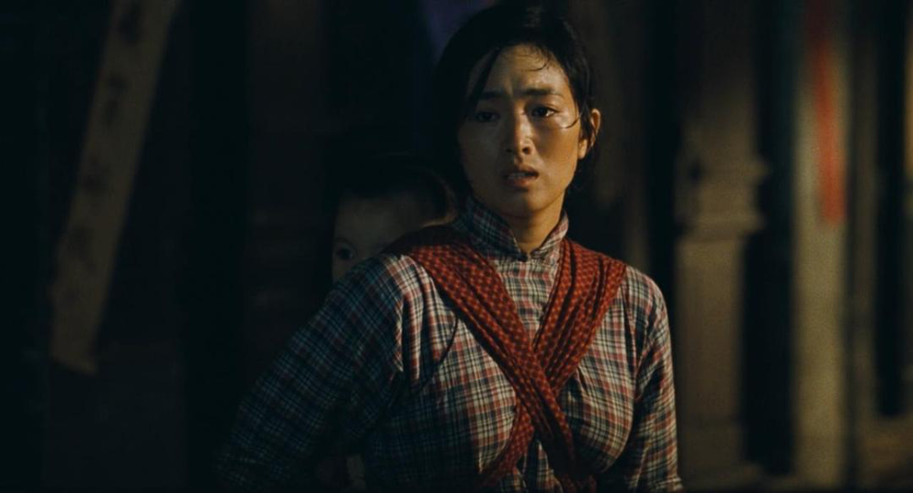 1994年电影《活着》剧照,家珍(巩俐饰)电影《活着》也直接把张艺谋推