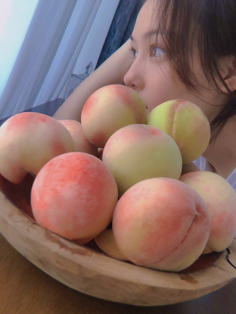张馨予|张馨予晒出自家丰收的桃子，没想到脸比桃子还粉嫩，看到侧颜心动了