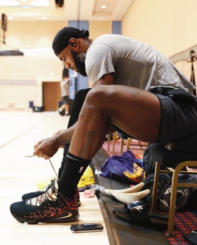 张便是詹姆斯坐在球场边系鞋带的照片,詹姆斯小腿肌肉的线条非常明显