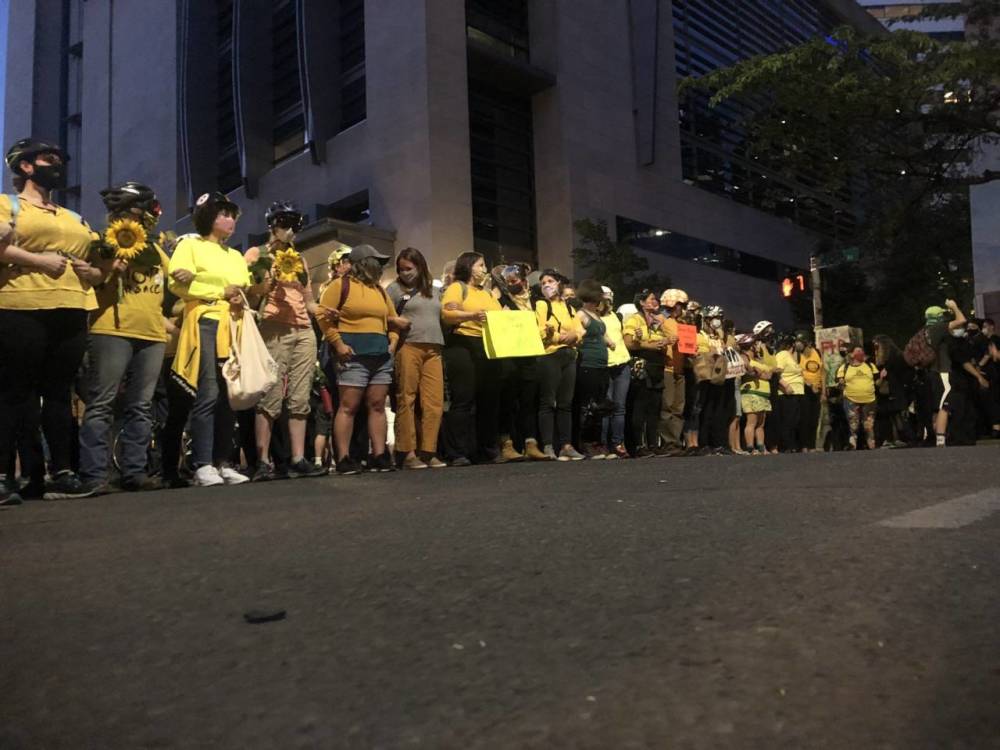 波特兰|波特兰示威者又出“新花活”：妈妈们上街保护示威者，戴头盔拉成“人墙”