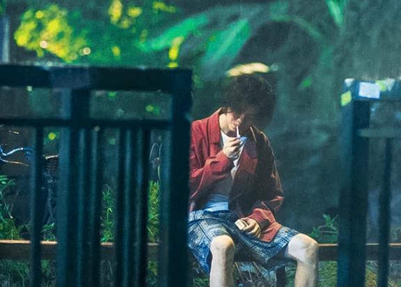 再比如,鹿晗在雨中坐着抽烟,低头点烟然后扔烟盒一气呵成,泡面头遮住