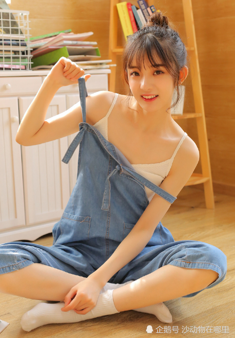 小姐姐身穿牛仔吊带呆萌望着镜头深情而又美丽