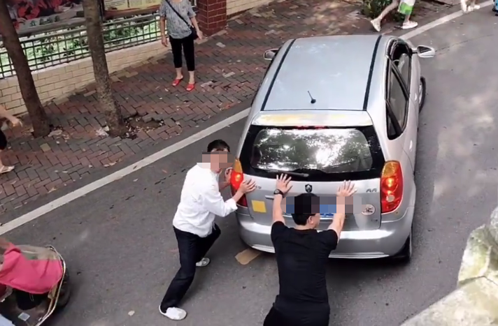 男司机停车忘拉手刹,众人合力帮忙推车,驾驶证是买来的吧