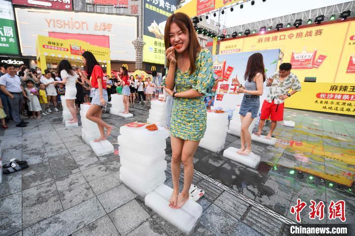 长沙市民高温天挑战站冰块吃辣条解暑