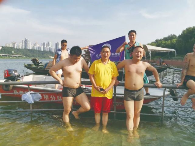 ▲获救的两名游泳青年(前排左一、右一)与救援队员合影。株洲市湘江义务救援协会供图