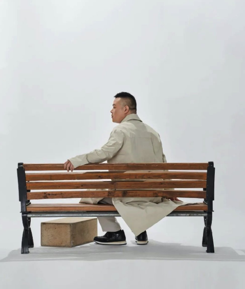 浅驼色的大衣穿搭下,孤独的街边座椅里,脚下还躺着一个盒子,你是否能