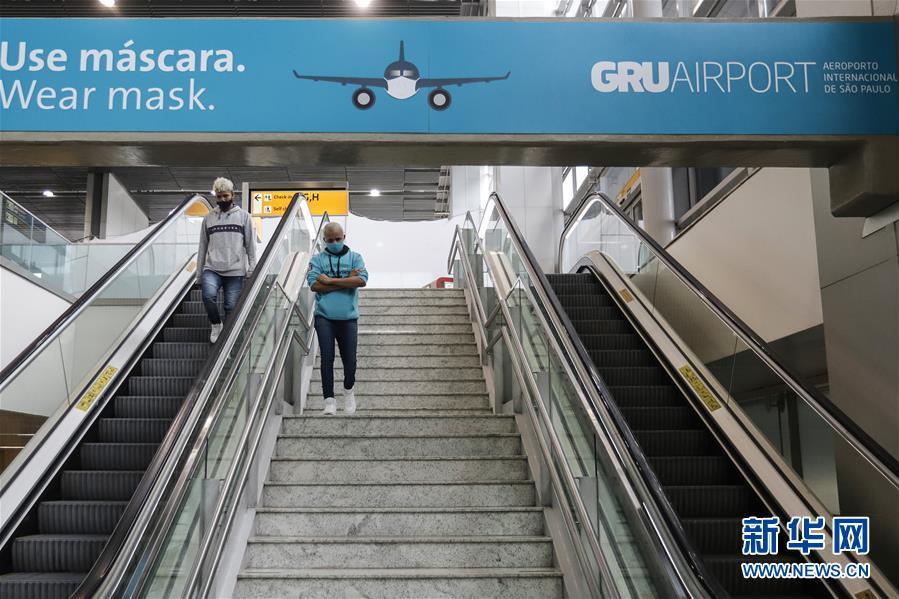 这是7月30日在巴西圣保罗瓜鲁柳斯国际机场内拍摄的提醒民众佩戴口罩