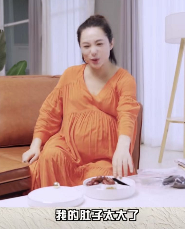 视频中,刘璇半扎头发,身穿橙色连衣裙化着淡妆,虽然因为怀孕脸部略显