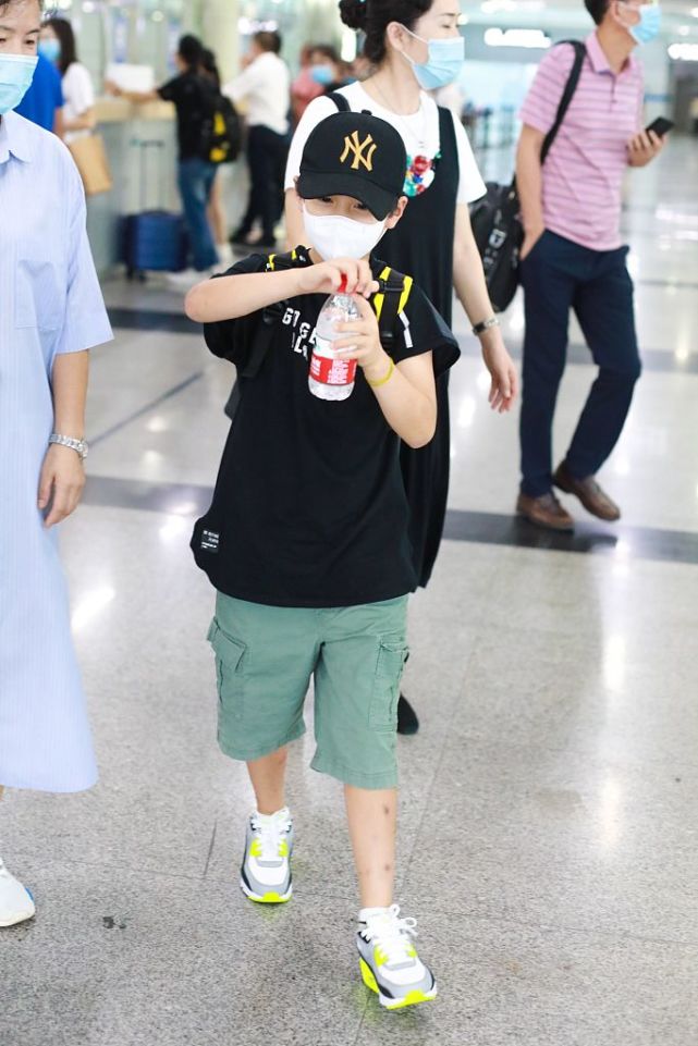 郑钧带儿子搭机造型很休闲 萌娃郑熙岳忙拧瓶盖笑眼可爱