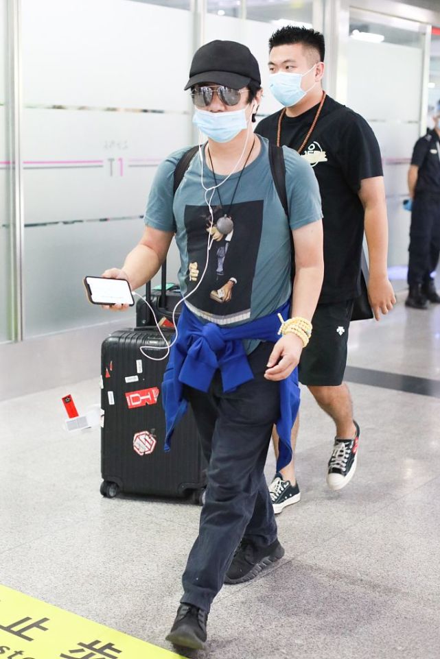 郑钧带儿子搭机造型很休闲 萌娃郑熙岳忙拧瓶盖笑眼可爱