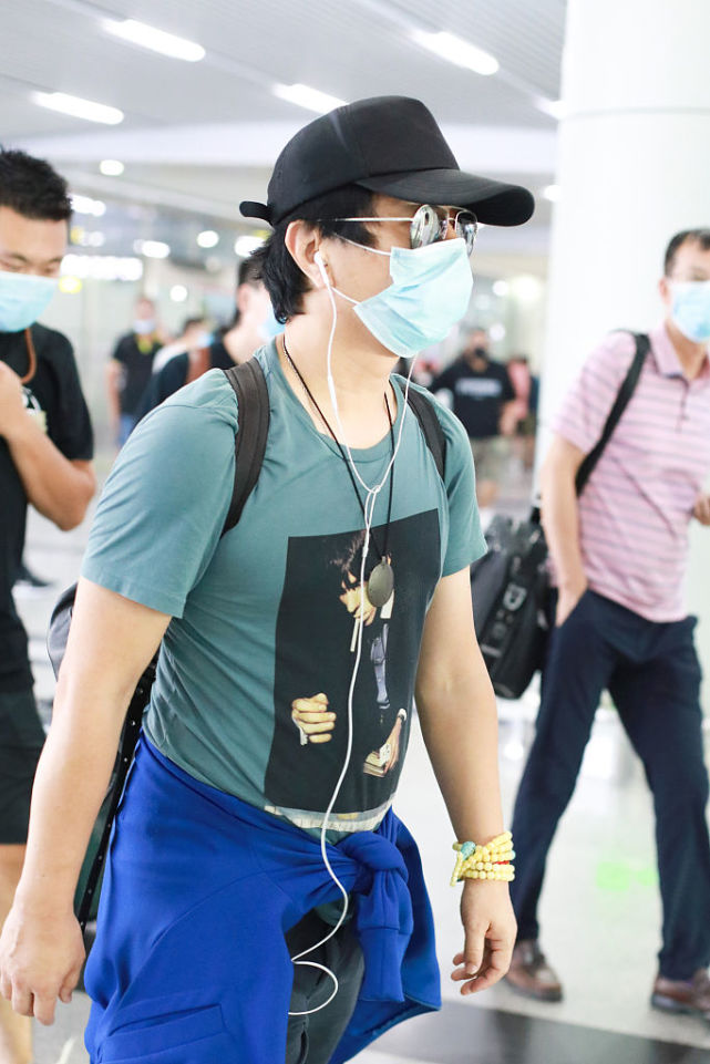 郑钧带儿子搭机造型很休闲 萌娃郑熙岳忙拧瓶盖笑眼可爱