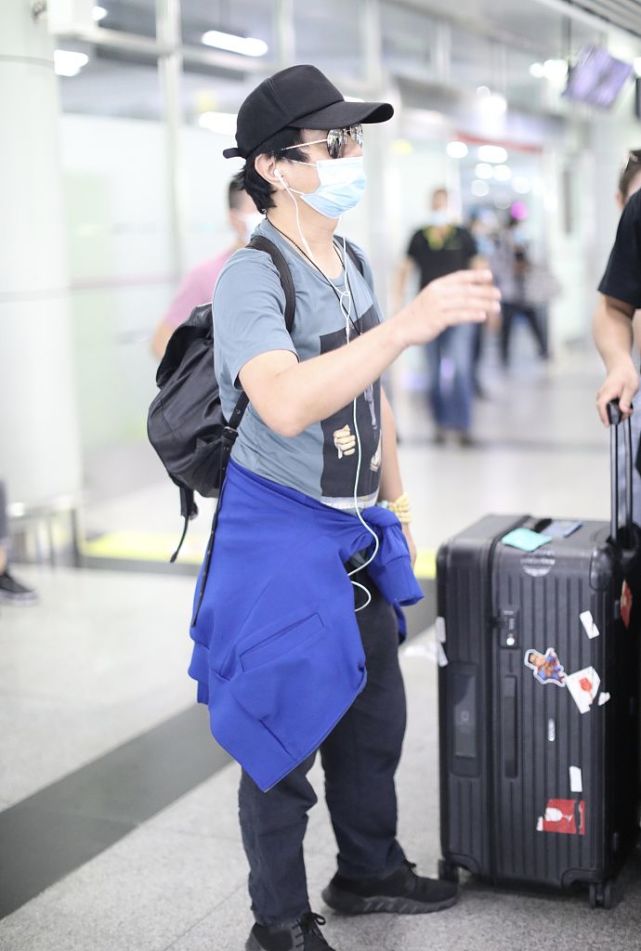 郑钧带儿子搭机造型很休闲 萌娃郑熙岳忙拧瓶盖笑眼可爱