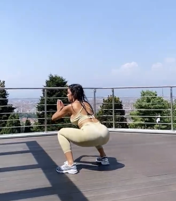 当天乔治娜穿着米色的瑜伽套装,背对着镜头为大家展示标准的波比跳