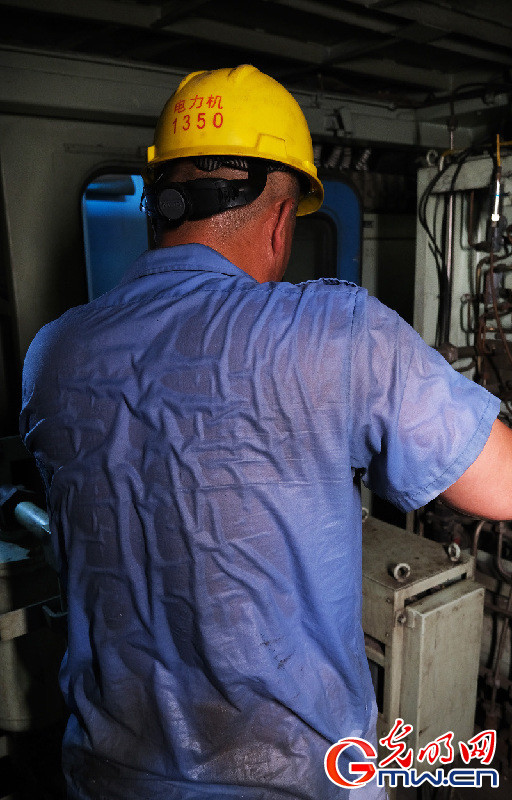 8月4日,检修人员在机车内冒着摄氏50°以上高温汗流浃背检修制动系统.