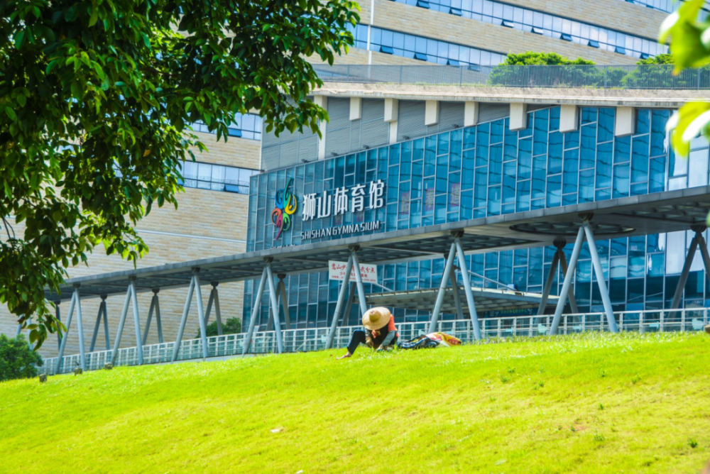 狮山体育馆外,市政工人在烈日下作业