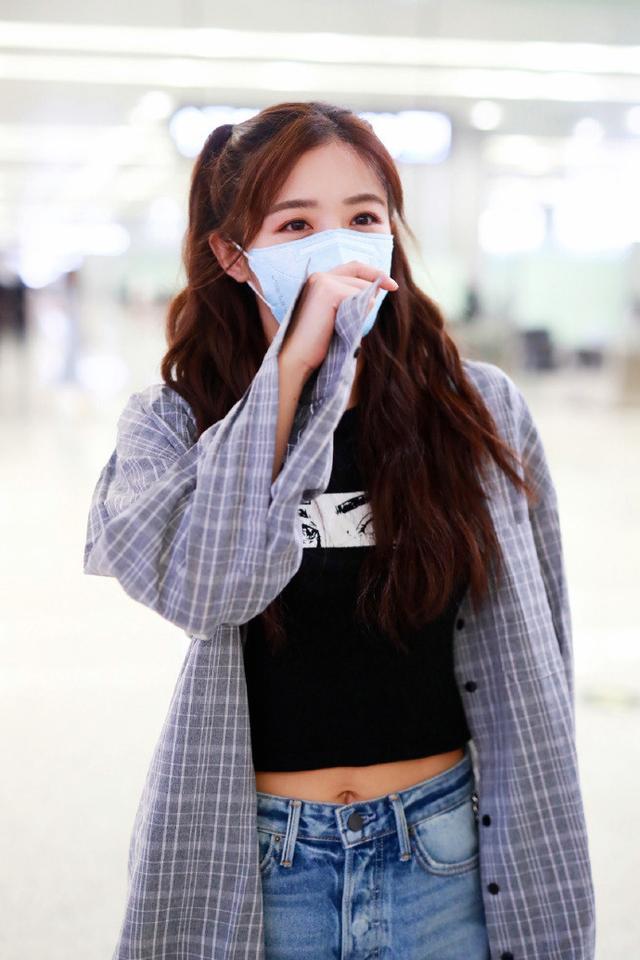 近日张含韵现身机场她穿着黑色印花t恤下身搭配着一条牛仔短裤外搭着