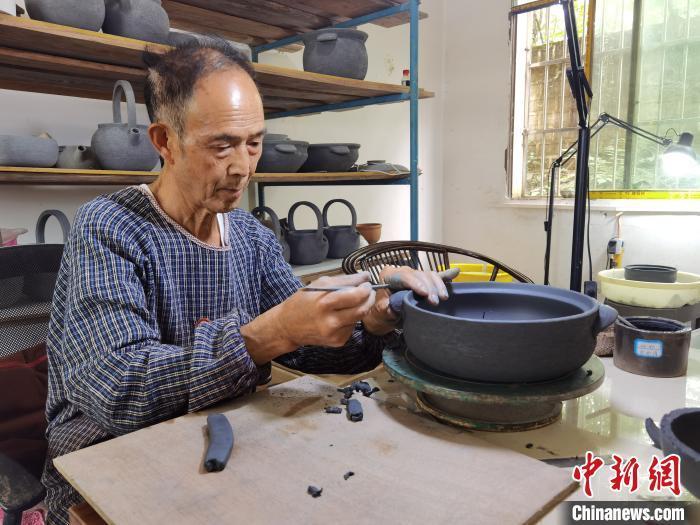 胡正德制作黑砂陶锅. 周燕玲 摄