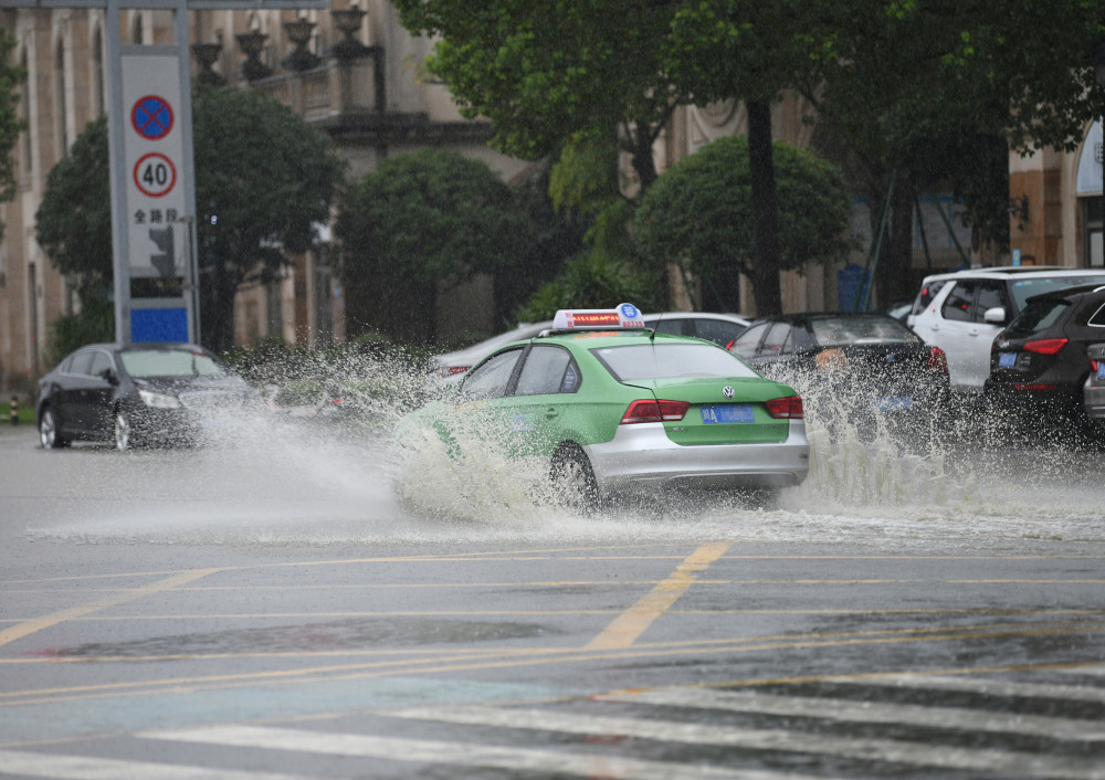 暴雨中成都路面积水车辆溅起浪花 江安河水漫过人行道