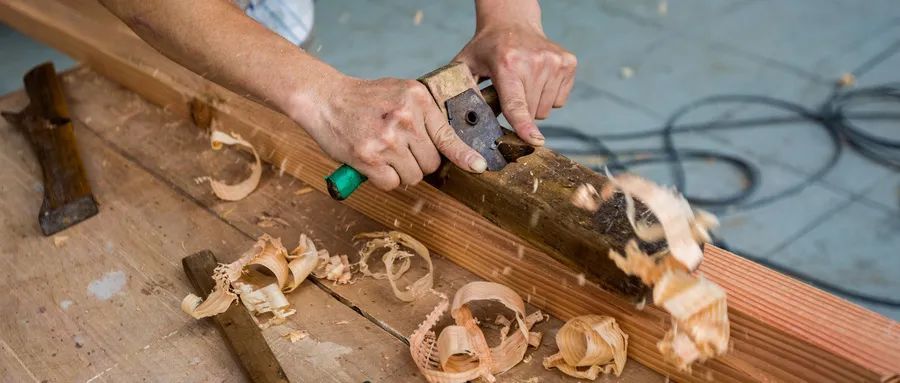 她写老木匠刨木板时,"一朵一朵蛋卷般的木花,一个挨一个,柔软地卷曲着