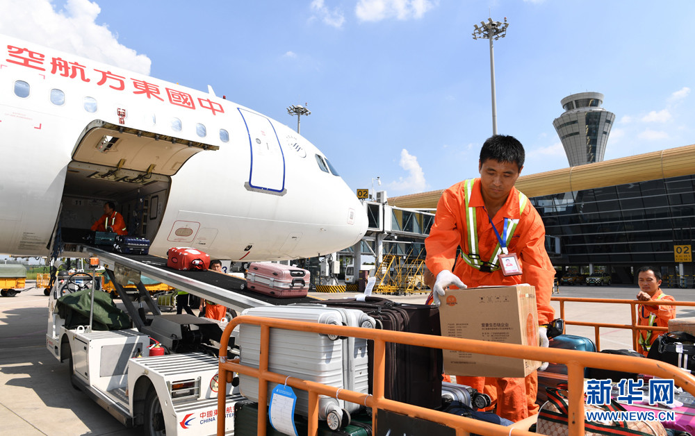 8月17日,在合肥新桥国际机场停机坪, 行李装卸员正在搬运行李.