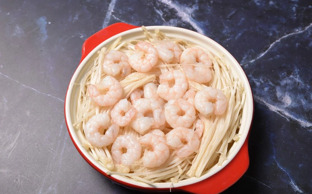 1,首先把虾仁焯水后捞出,加入一勺盐,适量料酒腌制,将金针菇均匀铺在