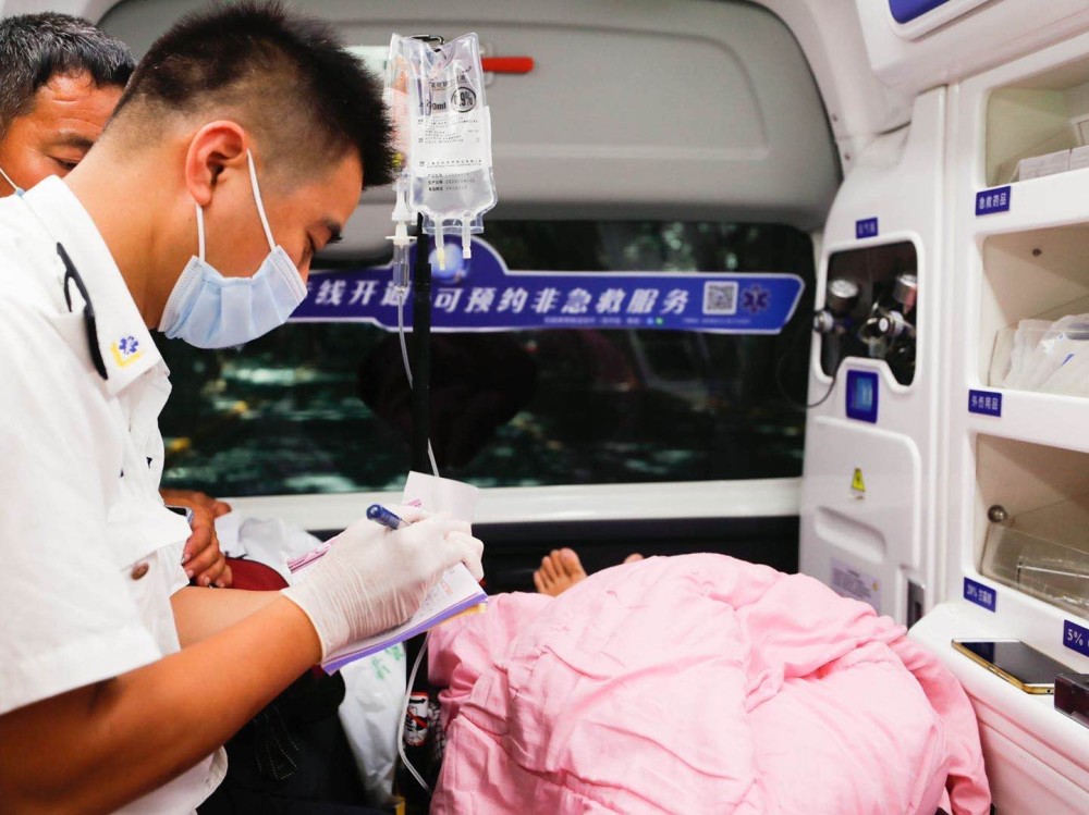 120急救医生在救护车上询问病人病情并做好记录.