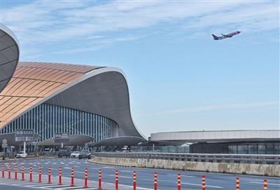 版摄影/新京报记者 陶冉昨日,北京大兴国际机场,旅客通过廊桥走入飞机