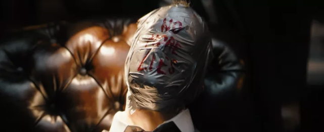 一个脸上缠满了胶带似乎已经窒息而亡的人,脸上写着"别再撒谎了".