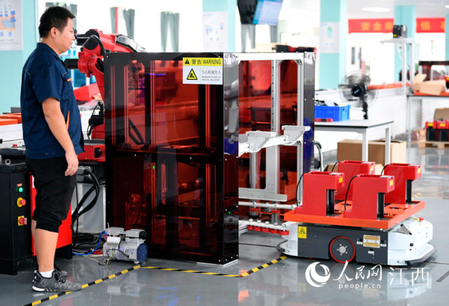 "挥舞"着手臂给变电设备安装"智慧的大脑",工作人员则在安全线外"监工