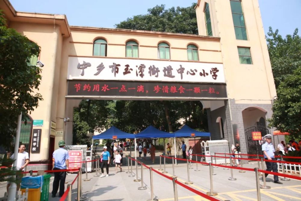 玉潭街道中心小学在长郡沩东中学,每位学生和家长进校都需测量体温,并