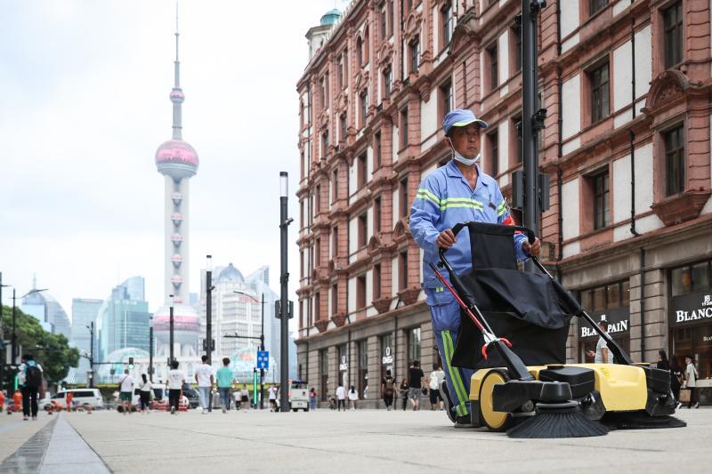 环卫工人正在清洁已经铺好地砖的南京路步行街东拓段.