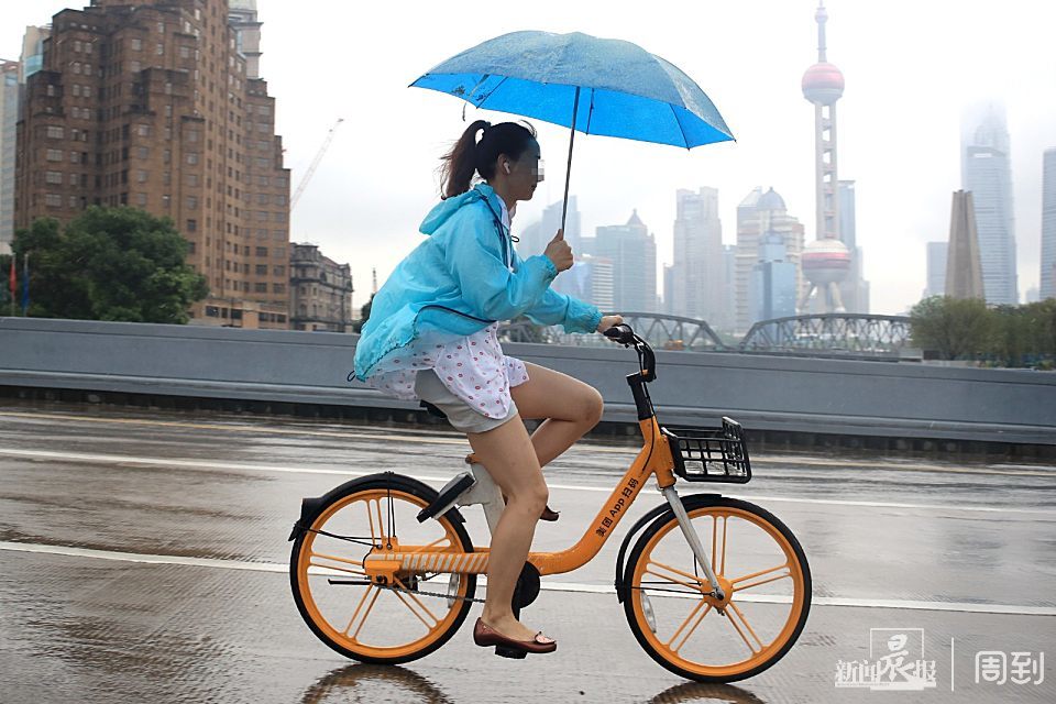 年轻女士雨中撑伞骑车摔倒,切记,撑伞骑车很危险