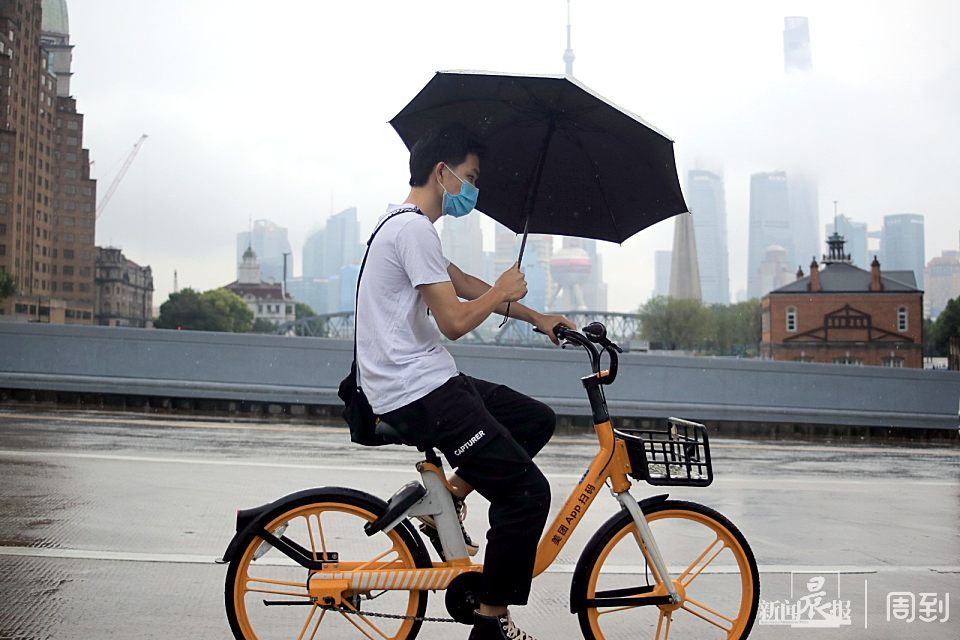 年轻女士雨中撑伞骑车摔倒,切记,撑伞骑车很危险