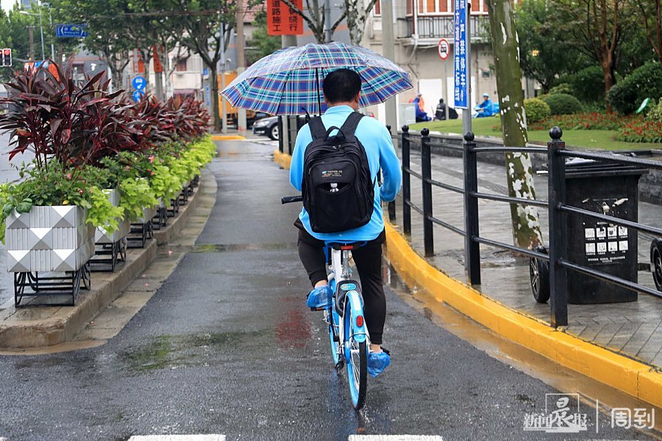 年轻女士雨中撑伞骑车摔倒,切记,撑伞骑车很危险