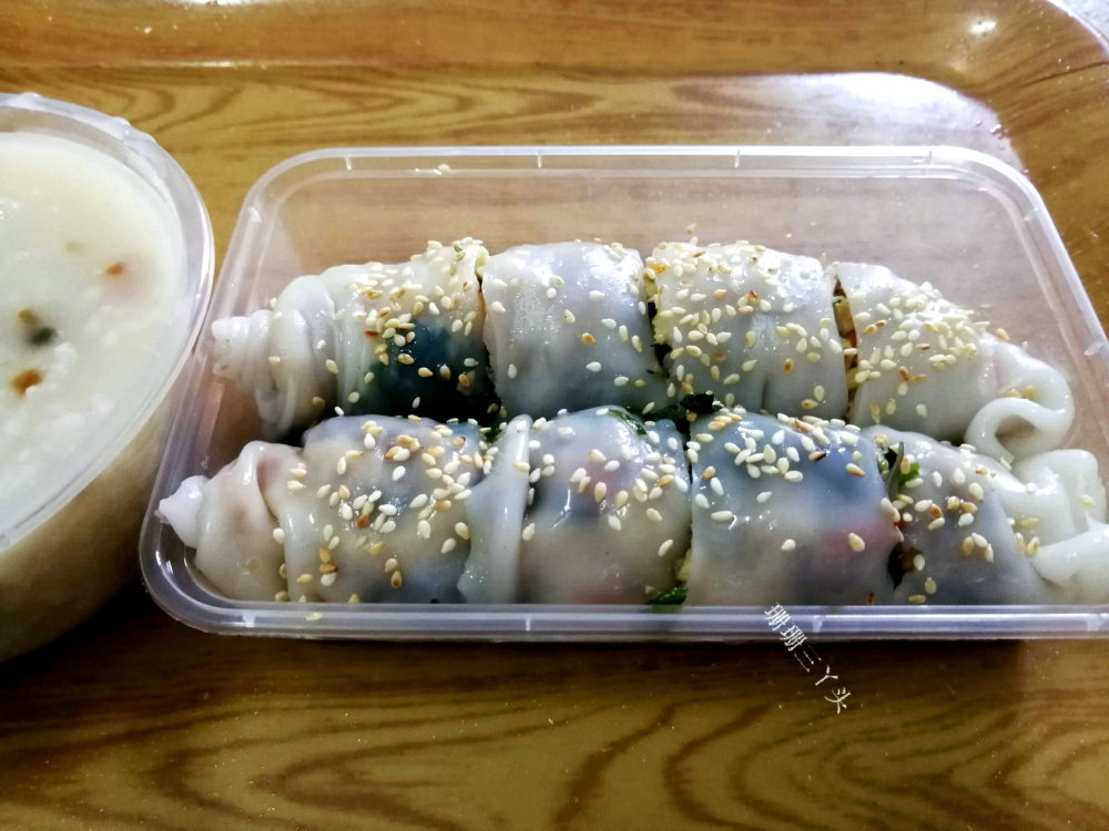 广东湛江尝小吃用根竹篾制粉皮卷上馅料游客像胖子
