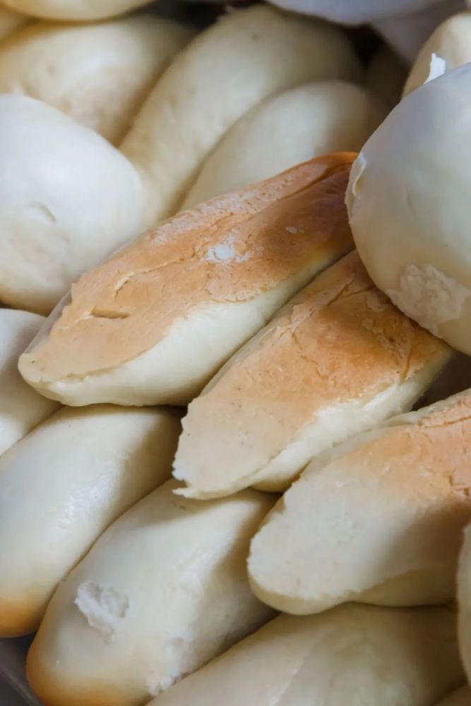 揉好的面团一个个搓成"三寸金莲"的小脚模样,贴在锅壁上.