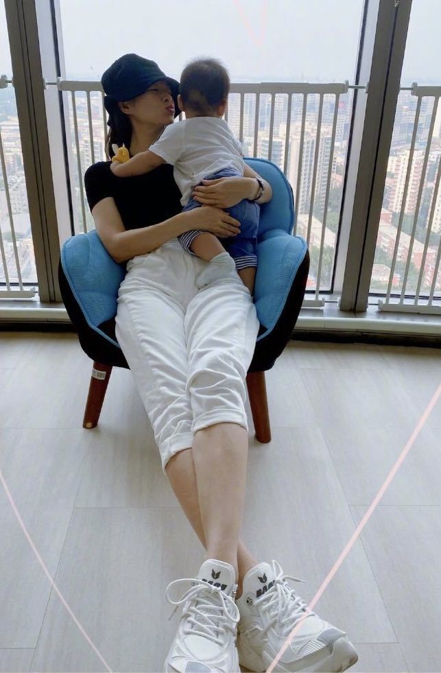 章子怡|章子怡抱儿子阳台看风景，小家伙手拿磨牙棒，喝奶翘腿超活泼