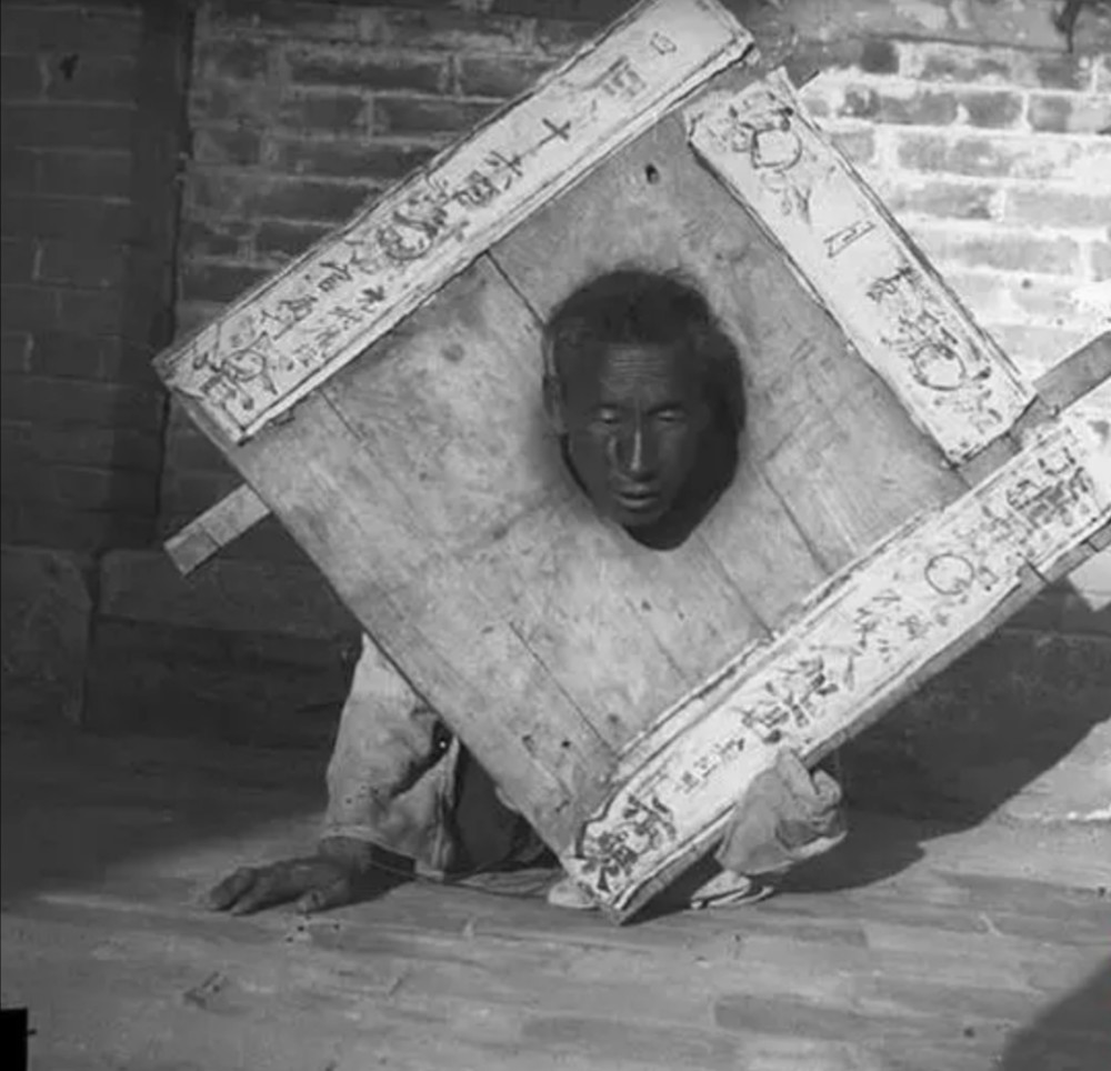 犯人的枷刑,几十斤重的木枷让犯人都不堪其重.