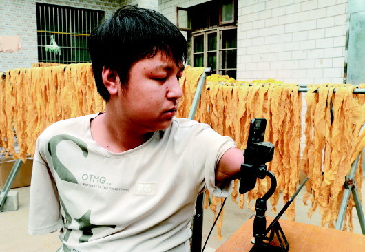 无臂主播咬筷子打字做直播养全家