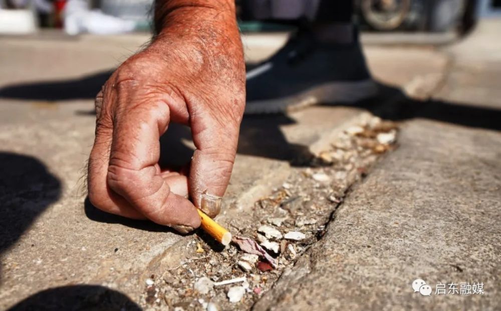 细心的吴老又发现了几个被"卡住"的烟头,他缓缓弯下腰伸手去捡,烟头