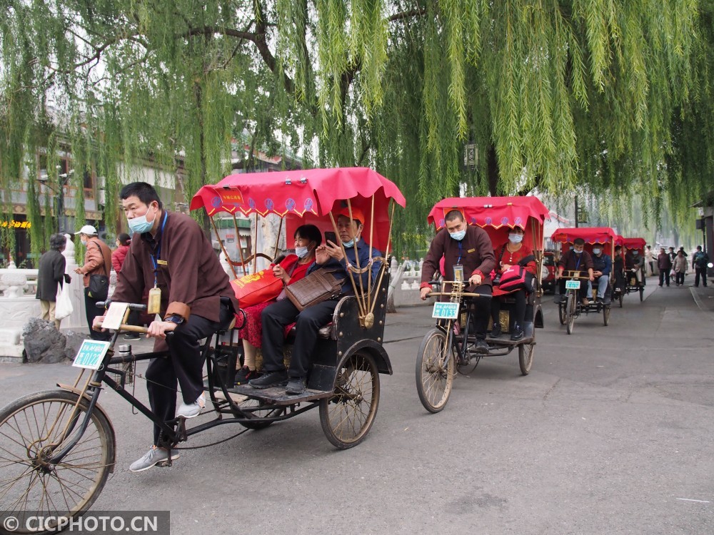 以上图片:2020年10月20日,游客乘坐人力客运三轮车在北京什刹海风景区