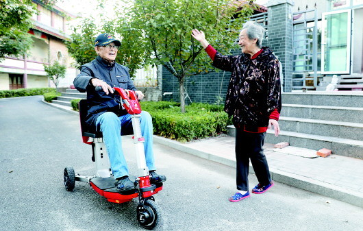 计凤鸣骑着电动车回家,老伴在门口等候.