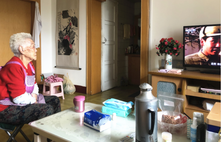 张女士的母亲坐在暖和的房子里看电视.记者 季蓉 摄