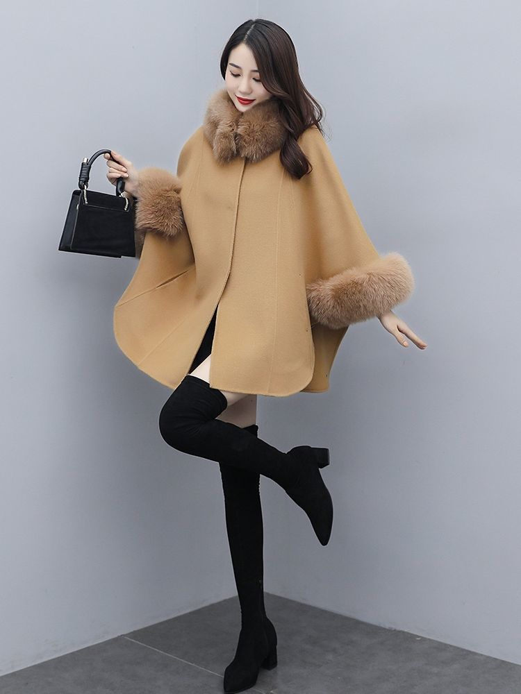 红色的斗篷羊绒短款大衣尽显洋气范儿,带有黑色毛领和黑色蝴蝶结,显出