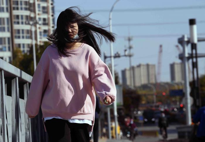 风中骑行的人们全副武装抵御风寒.