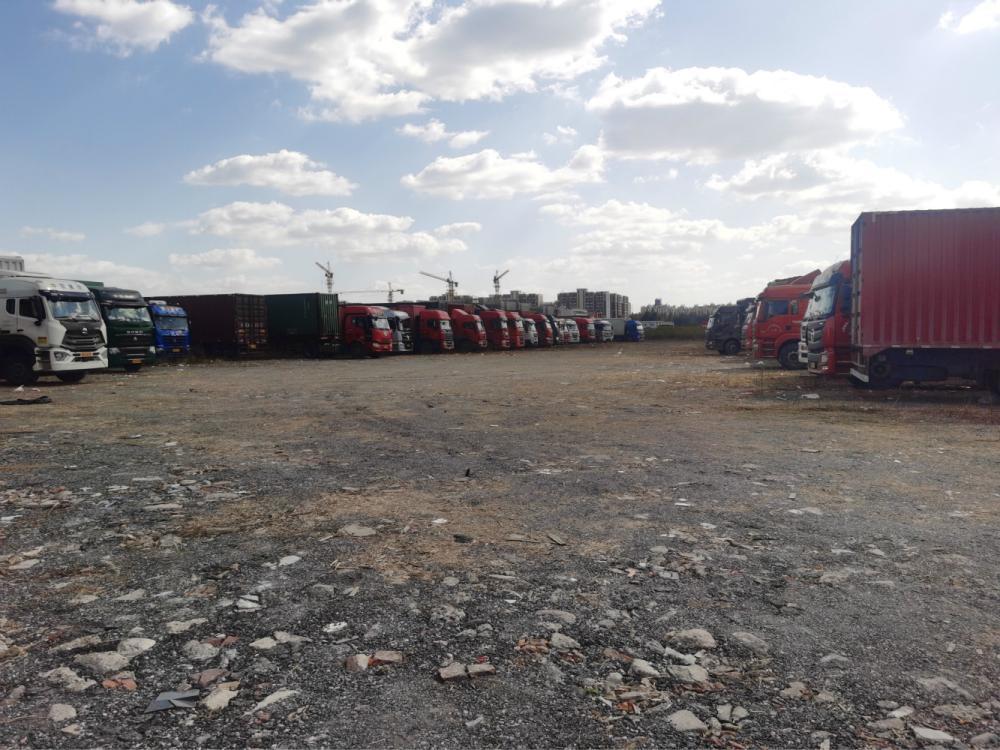 在临时停车场等候的货车排成一列.