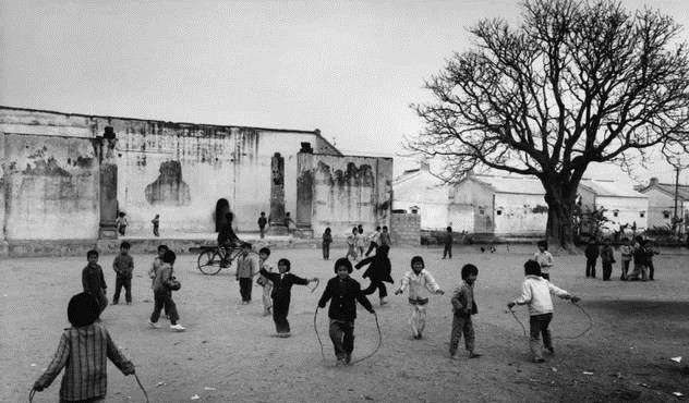 80年代中國歷史老照片:圖為一個小學的操場上,一群小孩子在操場上跳繩