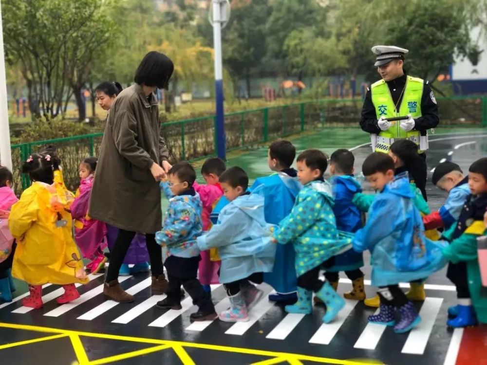 幼儿园老师带小朋友过马路,社会秩序教育意义重大,要从娃娃抓起
